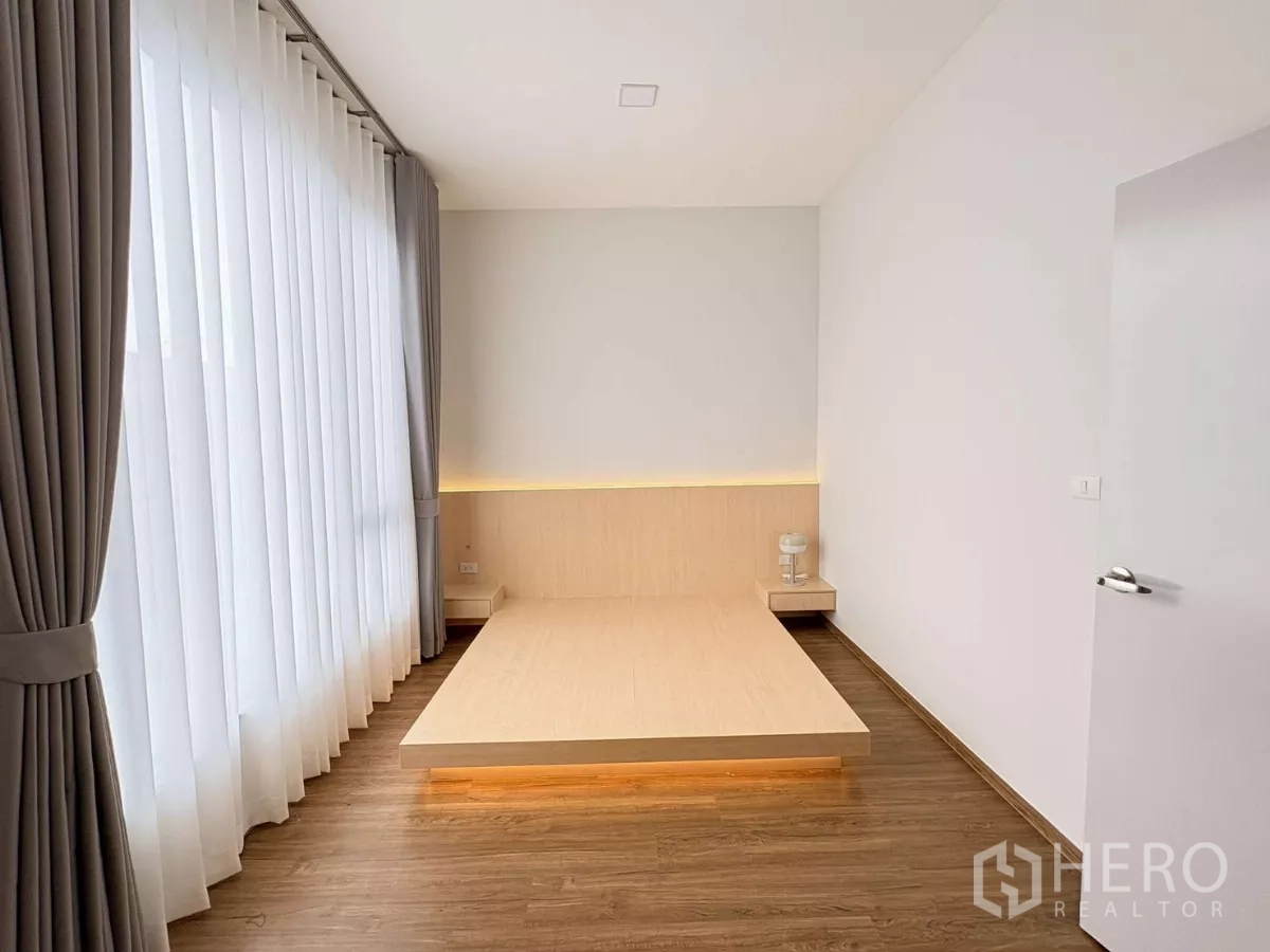 Townhouse for rent in Bang Phli, Samut Prakan - Minimalist bedroom with platform bed, soft LED lighting and large window.
