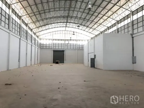 โรงงาน ให้เช่าในLam Luk Ka, Pathum Thani - ภายในคลังสินค้าโล่งกว้าง หลังคาโค้งโครงเหล็ก มีช่องรับแสง พื้นคอนกรีตและประตูม้วนขนาดใหญ่