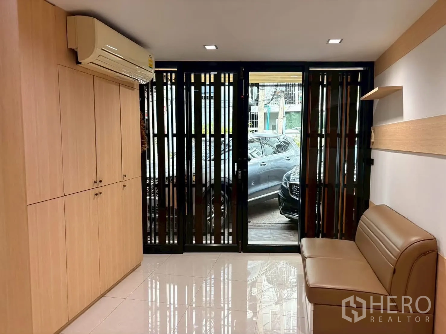 联排别墅 for rent in Pathum Wan, Bangkok - 一层玄关，内置柜、空调与推拉门通向停车区。