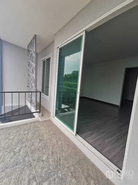 Home Office for rent or sale - Compact balcony with railing and sliding door overlooking greenery.