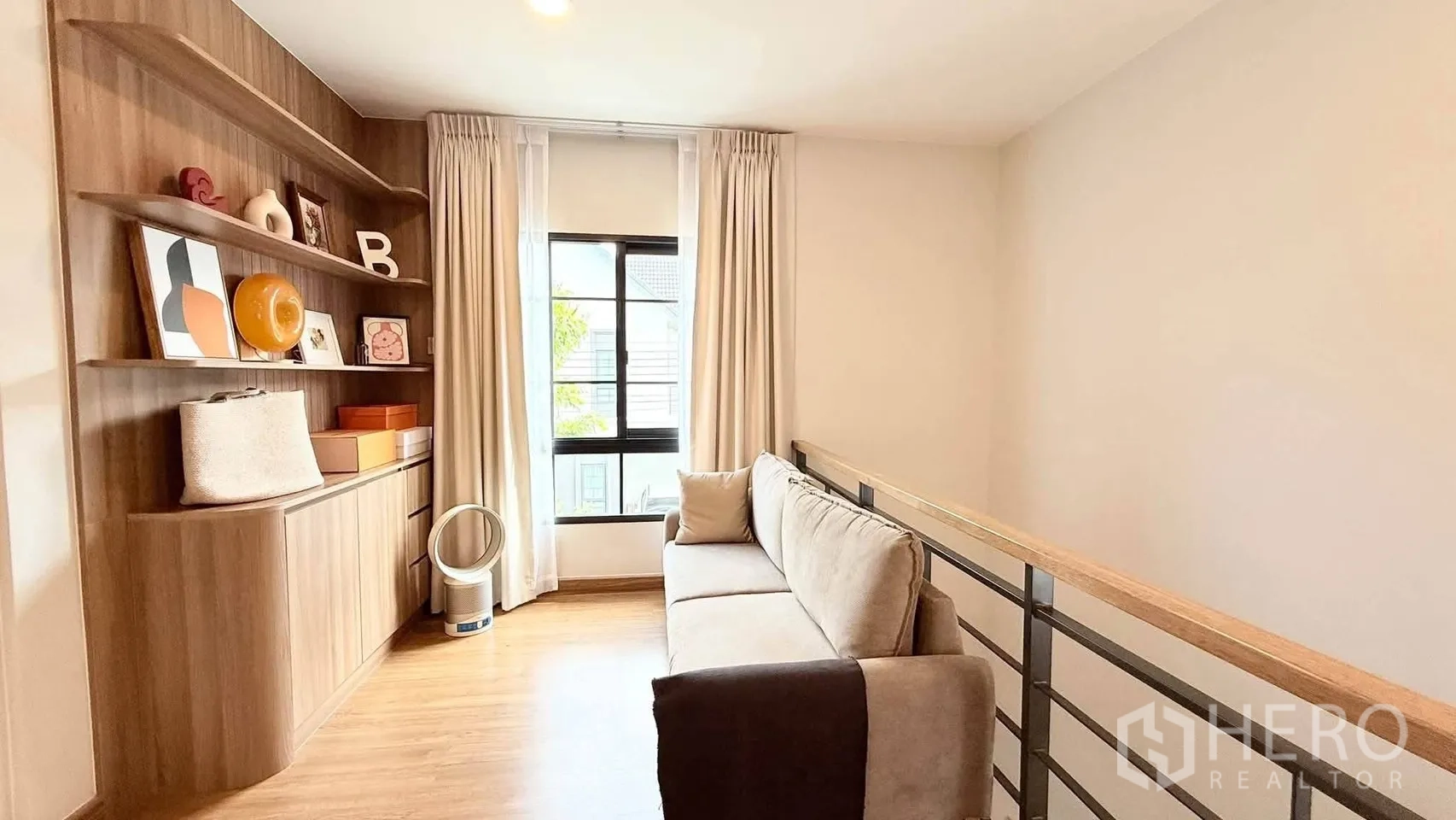 独栋房屋 for rent in Bang Phli, Samut Prakan - 二楼休闲区，设沙发与内嵌展示书架，临近楼梯护栏。
