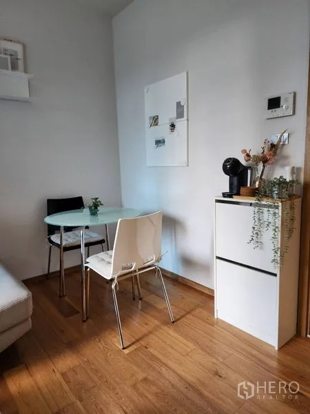 公寓 出租在Watthana, Bangkok - 温馨用餐角，圆形玻璃餐桌、两把椅子和咖啡机。