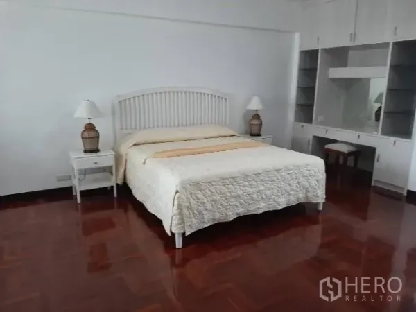 คอนโด ให้เช่าในKhlong Toei, Bangkok - ห้องนอนขนาดใหญ่เตียงคิงส์ไซส์ โคมไฟข้างเตียง พร้อมตู้เสื้อผ้าและโต๊ะเครื่องแป้งบิลท์อิน พื้นไม้ปาร์เกต์เงางาม