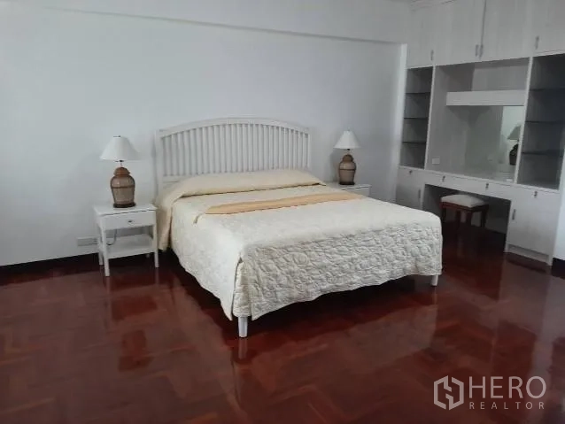 คอนโด ให้เช่าในKhlong Toei, Bangkok - ห้องนอนขนาดใหญ่เตียงคิงส์ไซส์ โคมไฟข้างเตียง พร้อมตู้เสื้อผ้าและโต๊ะเครื่องแป้งบิลท์อิน พื้นไม้ปาร์เกต์เงางาม