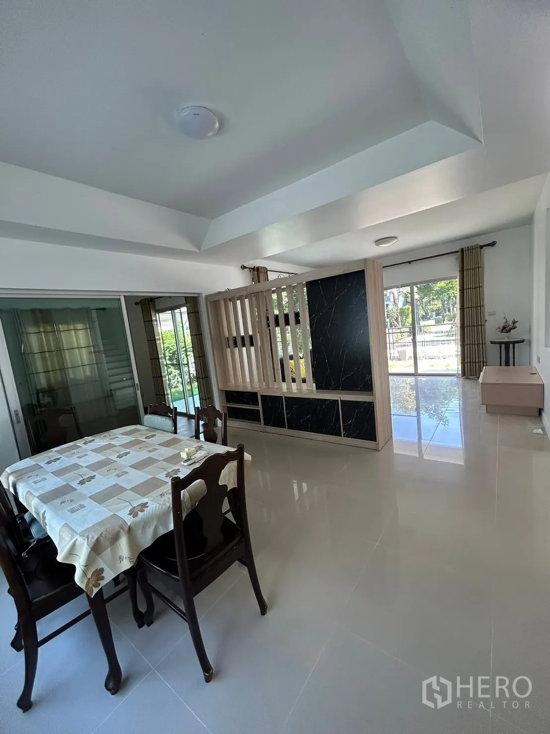 独栋房屋 for rent in Bang Na, Bangkok - 明亮餐区配四人餐桌、装饰隔断与推拉玻璃门。