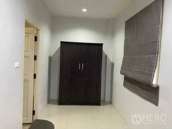 สำนักงานที่บ้าน ให้เช่าในKhlong Toei, Bangkok - ห้องเล็กมีตู้เสื้อผ้าสีเข้มและม่านโรมันสีเทาใกล้ประตู