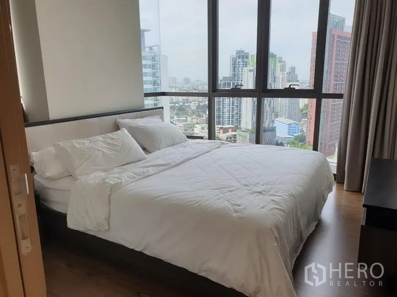 คอนโด ให้เช่าในWatthana, Bangkok - ห้องนอนมุมกระจกกว้าง เตียงขนาดควีน ผ้าปูสีขาว พร้อมวิวสกายไลน์กรุงเทพฯ