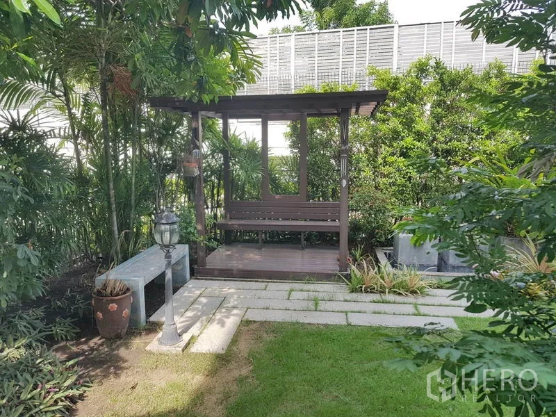 Detached House for sale in Bang Kapi, Bangkok - Landscaped garden featuring a wooden pavilion and stone pathway surrounded by tropical plants.