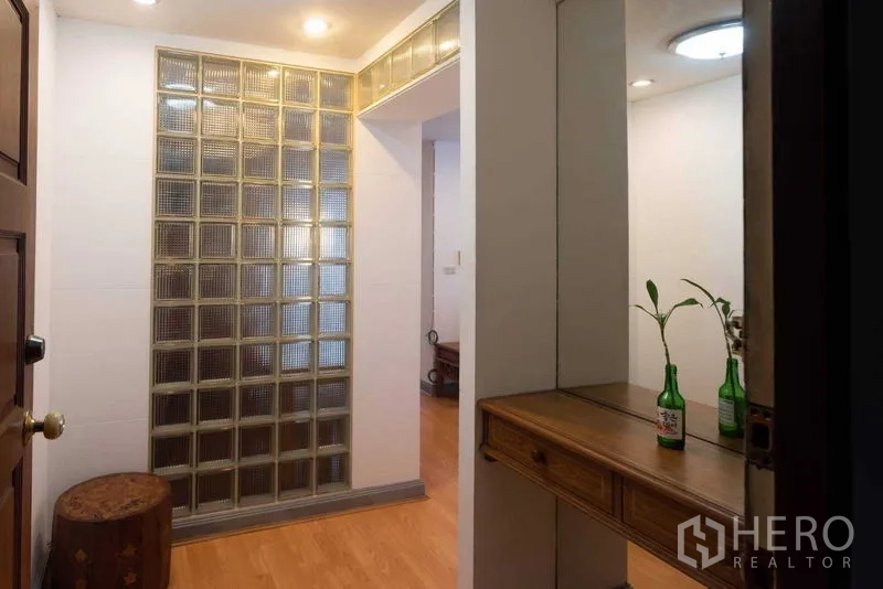 Condominium for rent in Ratchathewi, Bangkok - Entry hallway with glass-block partition, wood flooring and console.