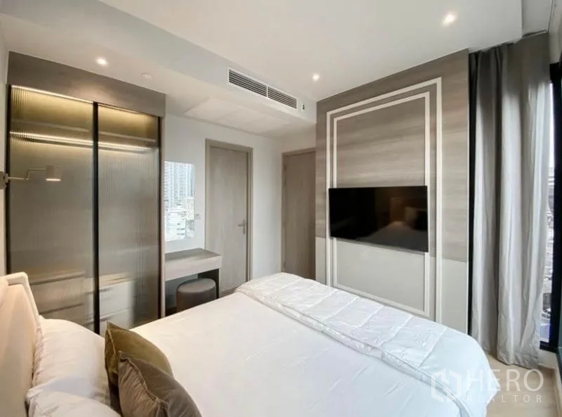 Condominium for rent in Din Daeng, Bangkok - Master bedroom opposite view with sliding wardrobe, study nook and TV wall.