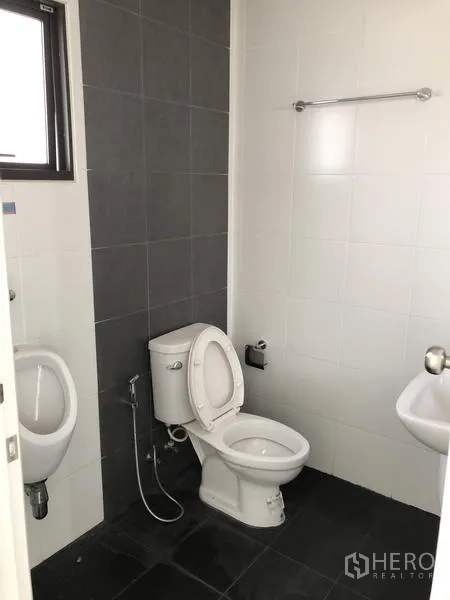 货栈 出租或出售在Lam Luk Ka, Pathum Thani - 干净卫生间，配坐便器、小便斗、洗手盆与瓷砖墙面。