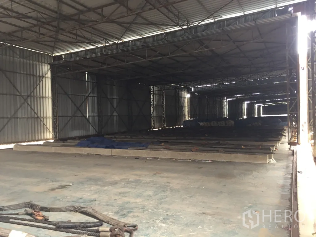 货栈 出租在Mueang Pathum Thani, Pathum Thani - 仓库内部空间通透，钢桁架屋顶与混凝土地面，侧面自然采光，适合存储。