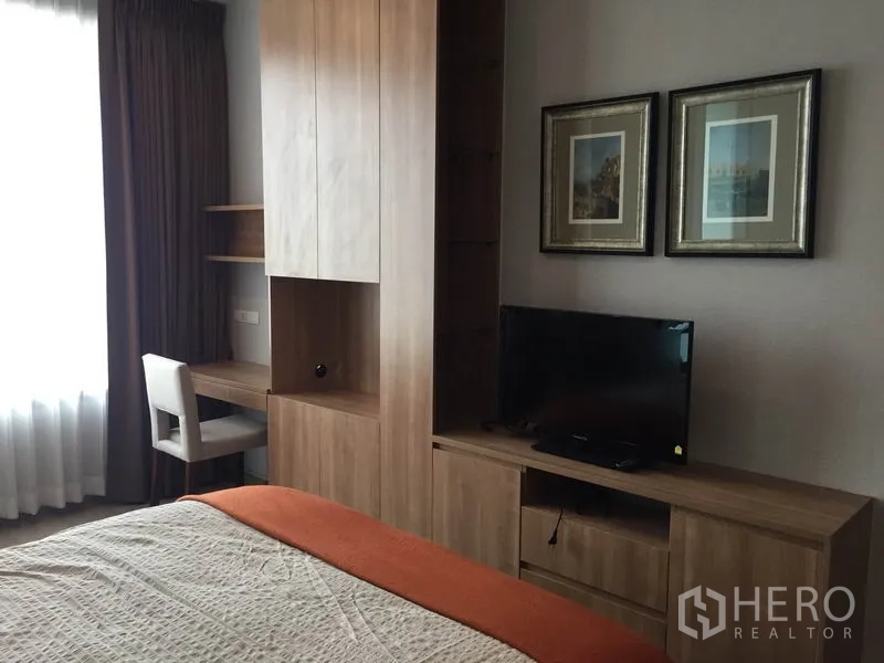 Condominium for rent in Ratchathewi, Bangkok - Master bedroom storage wall with TV cabinet, wardrobe and work desk.
