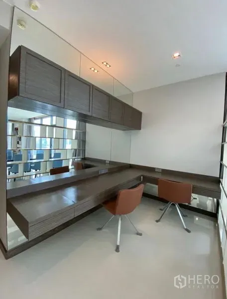 公寓 出租在Khlong Toei, Bangkok - 明亮书房/梳妆区，整面镜墙，悬浮书桌与两把现代椅。