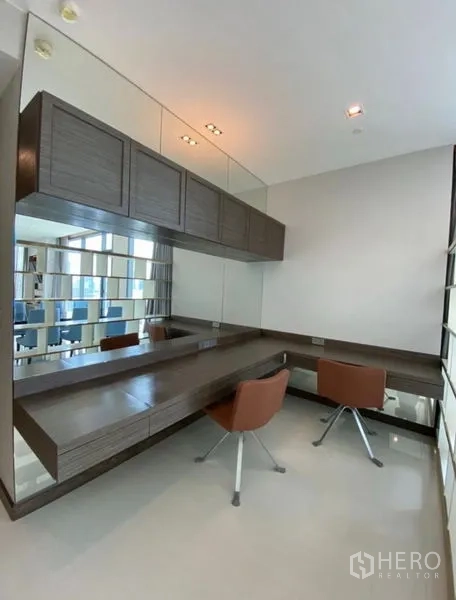 公寓 出租在Khlong Toei, Bangkok - 明亮书房/梳妆区，整面镜墙，悬浮书桌与两把现代椅。