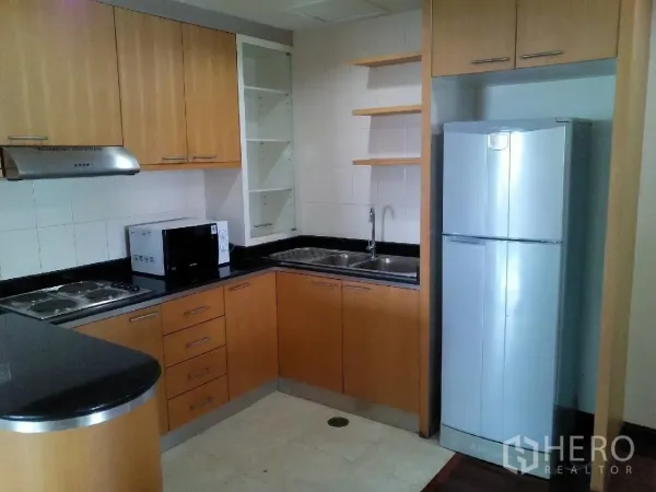 คอนโด ให้เช่าในPhaya Thai, Bangkok - ครัวรูปตัวแอล ตู้ไม้ เคาน์เตอร์หินสีดำ เตา เครื่องดูดควัน ไมโครเวฟ และตู้เย็นสแตนเลส