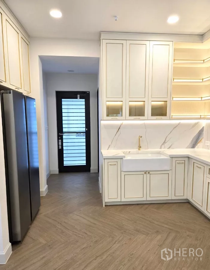 Detached House for rent in Saphan Sung, Bangkok - Western kitchen with white cabinetry, marble backsplash and double‑door fridge.
