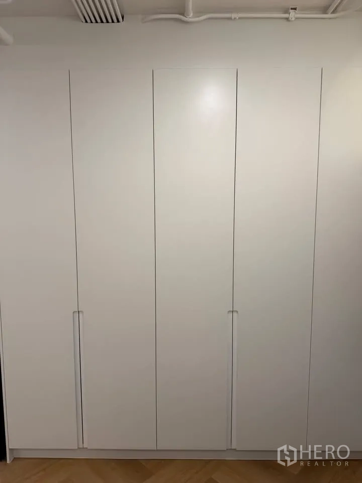 Condominium for rent in Watthana, Bangkok - Full-height white built-in wardrobes with minimalist handles.