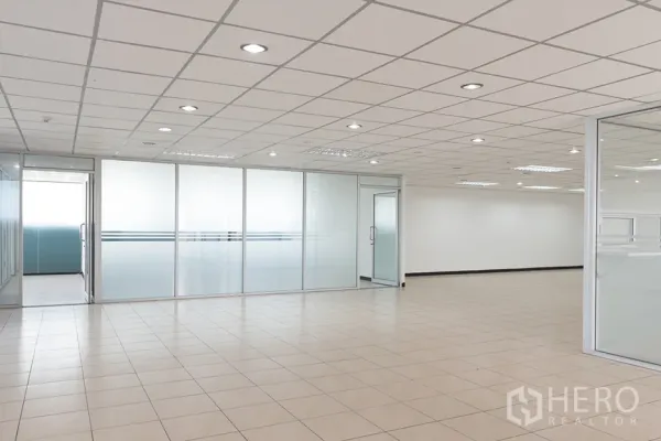 办公空间 出租在Din Daeng, Bangkok - 开放式办公区，米色地砖、嵌入式照明，带磨砂玻璃隔断的会议室。