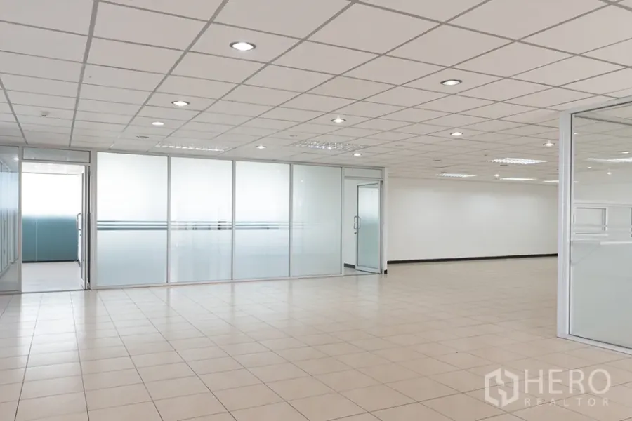 办公空间 出租在Din Daeng, Bangkok - 开放式办公区，米色地砖、嵌入式照明，带磨砂玻璃隔断的会议室。