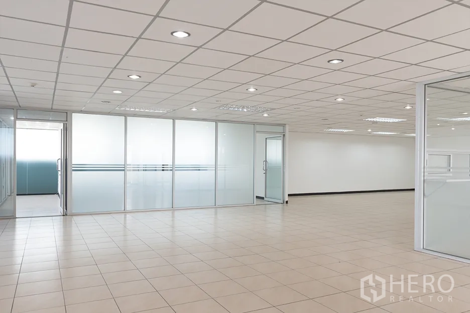 办公空间 出租在Din Daeng, Bangkok - 开放式办公区，米色地砖、嵌入式照明，带磨砂玻璃隔断的会议室。