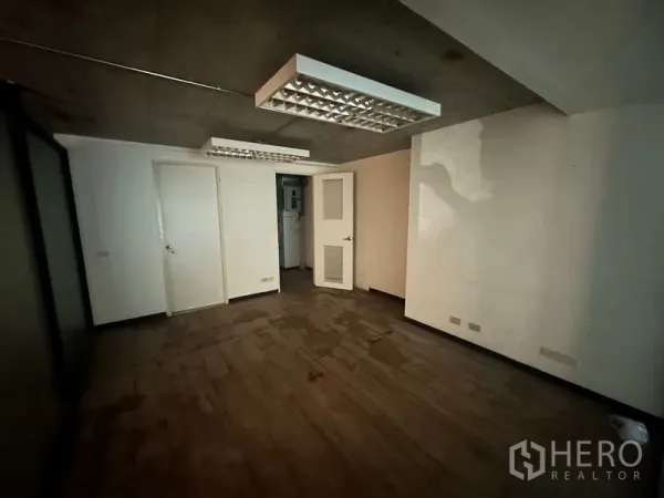 Office Space for rent in Khlong Toei, Bangkok - Private office with wood-look flooring, white walls and fluorescent ceiling light panels.