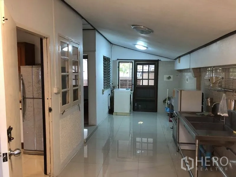 Detached House for rent - Long Thai kitchen and utility area with stainless counters, sink and back door.