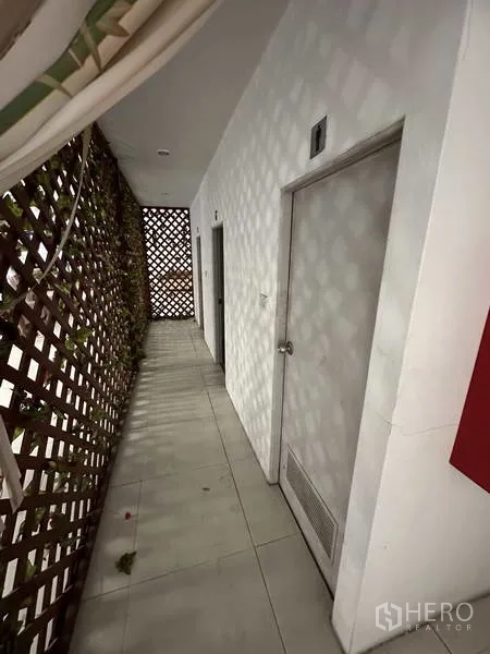 货栈 出租在Bang Khen, Bangkok - 铺砖走廊，设有房门与装饰格栅。