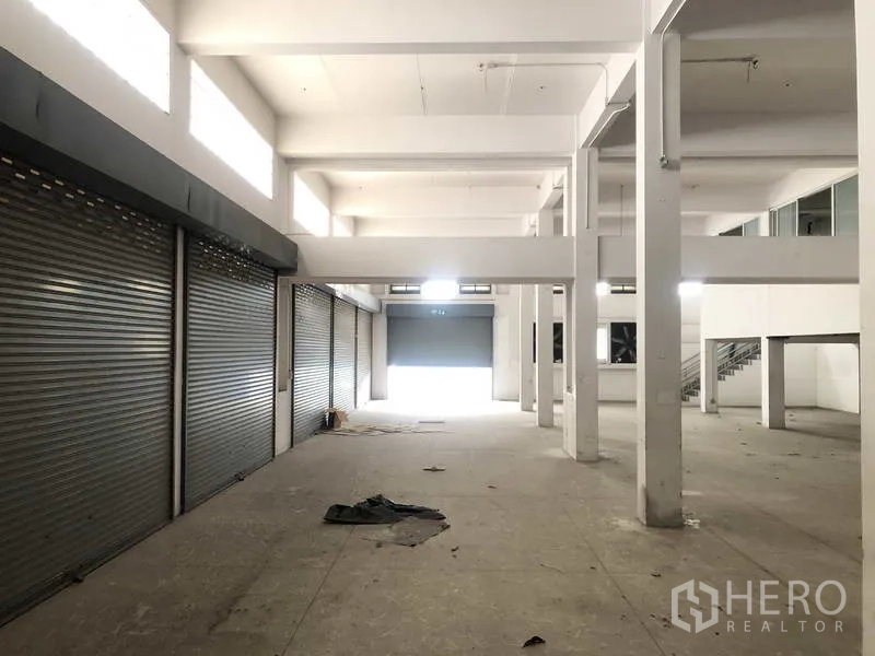 工厂 出租在Prawet, Bangkok - 底层多扇卷帘门，车辆可直接进出