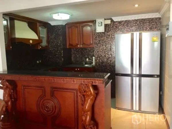 Condominium for rent or sale in Pathum Wan, Bangkok - Kitchen entry featuring a carved breakfast bar and stainless French-door refrigerator.