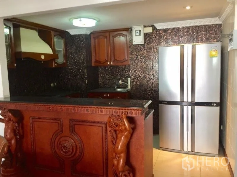 Condominium for rent or sale in Pathum Wan, Bangkok - Kitchen entry featuring a carved breakfast bar and stainless French-door refrigerator.