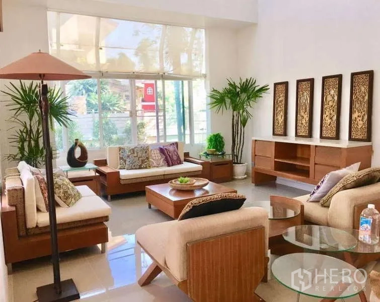 独立式住宅 出租在Lat Krabang, Bangkok - 挑高客厅，落地窗、米色沙发与木质家具。