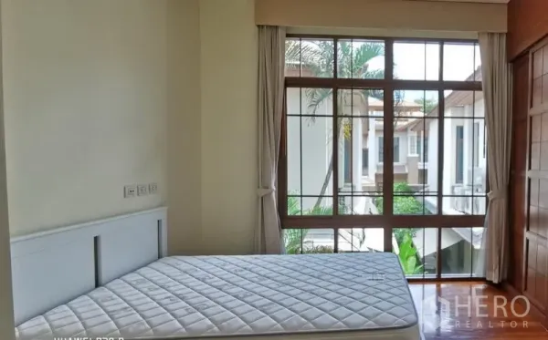 บ้าน ให้เช่าในWatthana, Bangkok - ห้องนอนพร้อมหน้าต่างสูงจรดพื้น ผ้าม่านสีอ่อน และที่นอนบนพื้นไม้