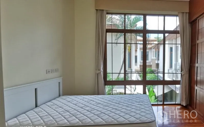 บ้าน ให้เช่าในWatthana, Bangkok - ห้องนอนพร้อมหน้าต่างสูงจรดพื้น ผ้าม่านสีอ่อน และที่นอนบนพื้นไม้