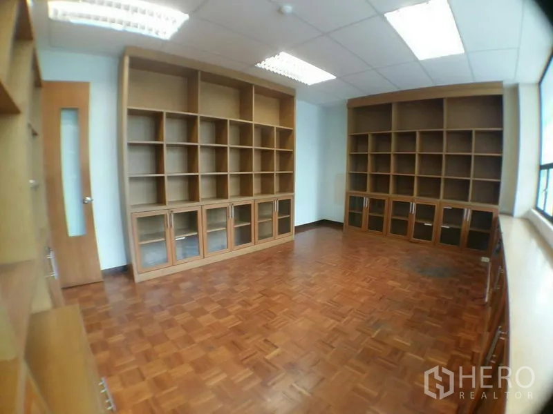 办公空间 出租在Phra Khanong, Bangkok - 会议/书房空间，拼花地板与整面木质书架。