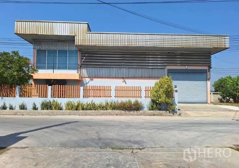 Warehouse for sale in Pathum Thani - Full front facade of the warehouse with office block and loading bay viewed from the road.