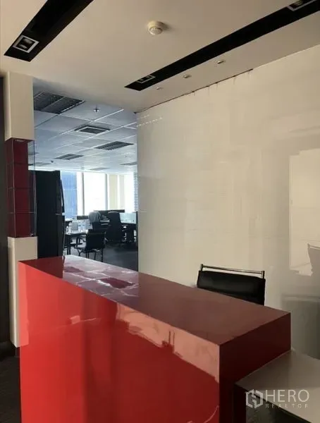 Office Space for rent in Huai Khwang, Bangkok - Reception area with a glossy red counter and a view into the open office.
