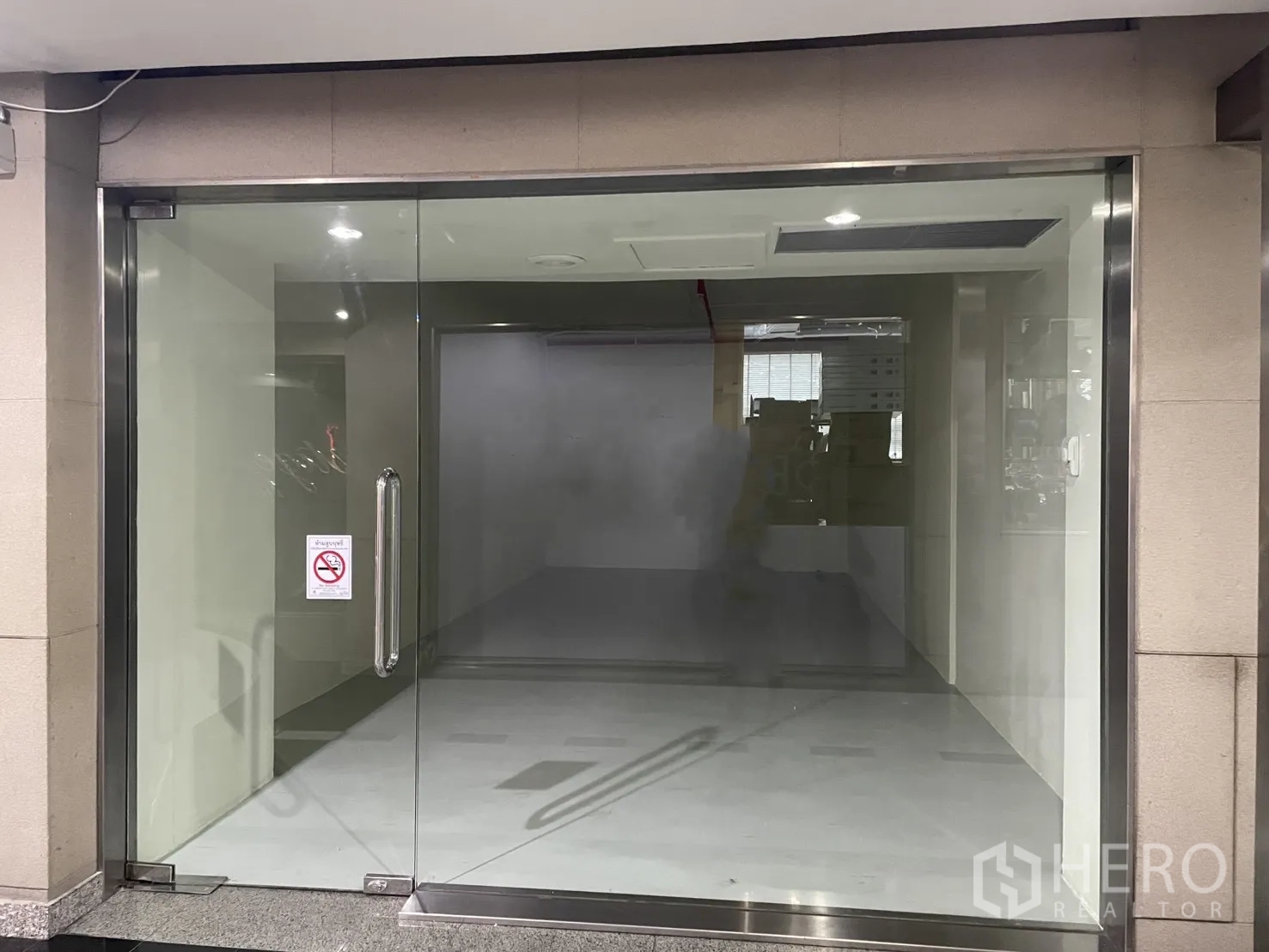 Retail Space for rent in Watthana, Bangkok - Glass storefront with double doors and stainless frame opening to an indoor mall corridor.