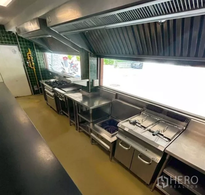 零售空间 出租在Yan Nawa, Bangkok - 商业炉灶与油炸机成排，置于大型排烟罩下的热厨线。