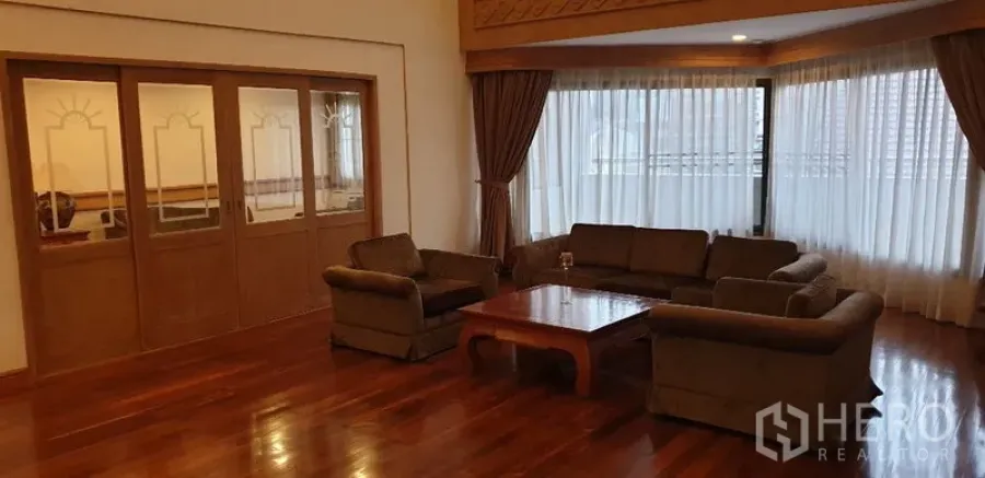 อพาร์ทเมนท์ ให้เช่าในWatthana, Bangkok - ห้องนั่งเล่นขนาดใหญ่ ชุดโซฟาและโต๊ะกลาง หน้าต่างมุมพร้อมผ้าม่านทึบรับแสงธรรมชาติ