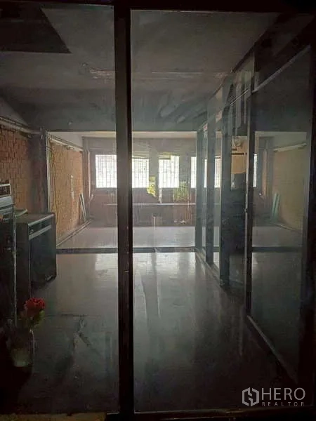 Shophouse for rent in Pom Prap Sattru Phai, Bangkok - View through glass panels into a bright front room with large windows.