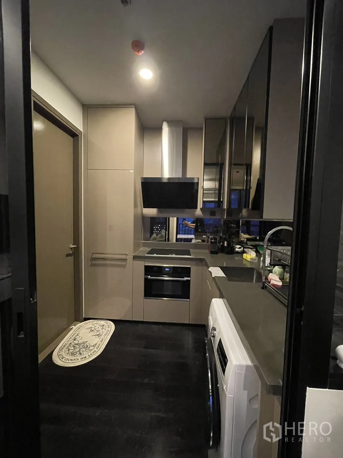 Condominium for rent in Watthana, Bangkok - Fitted kitchen featuring cooktop, oven, and range hood.