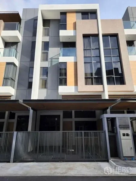 ทาวน์เฮาส์ ขายในYan Nawa, Bangkok - ด้านหน้าทาวน์เฮาส์สมัยใหม่หลายชั้น มีระเบียง หน้าต่างสูง และประตูรั้ว.