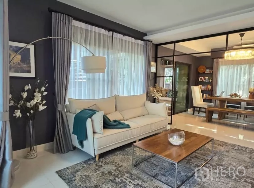 独立式住宅 出租在Bang Phli, Samut Prakan - 客厅采光充足，米色沙发、落地灯与纱帘和木质茶几