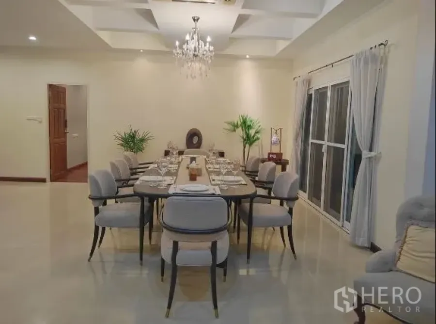 Detached House for rent in Huai Khwang, Bangkok - Formal dining room with chandelier and a long table set for dinner