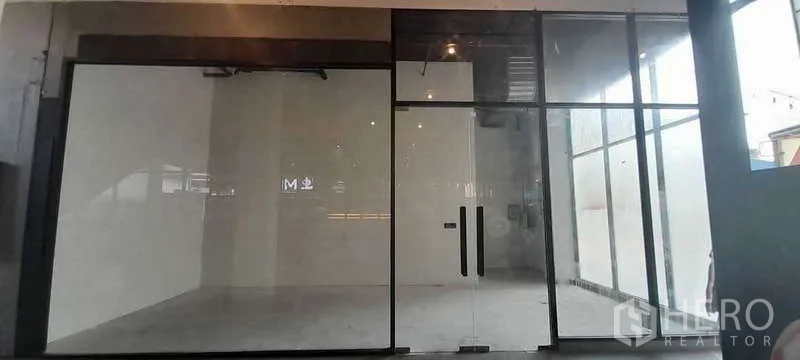 Retail Space for rent - Empty retail shopfront with full-height glass facade, double glass doors, white walls and concrete floor ready for fit-out in Sathon, Bangkok.