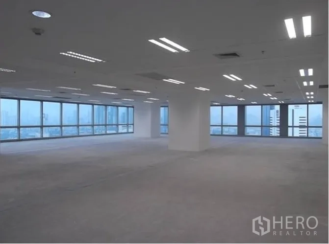 สำนักงาน ให้เช่า - พื้นที่สำนักงานขนาดใหญ่มีเสาคั่น พื้นคอนกรีตรอปู และหน้าต่างกระจกบานกว้าง
