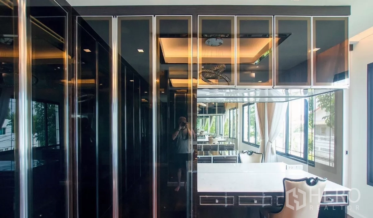 Detached House for rent in Bang Bon, Bangkok - Spacious walk-in closet with glossy wardrobes and a dressing table by the window.
