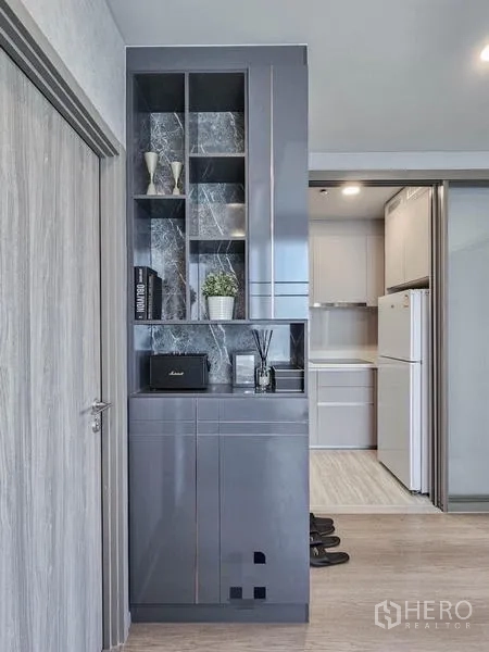 Condominium for rent in Samut Prakan - Built-in storage cabinet near the doorway leading to the closed kitchen.