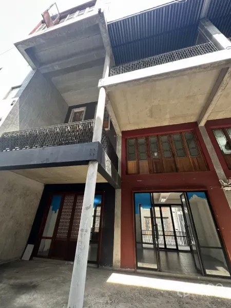 带办公室的家 出租在Pathum Wan, Bangkok - 多层住办楼外立面，混凝土结构，阳台与遮檐车位区。